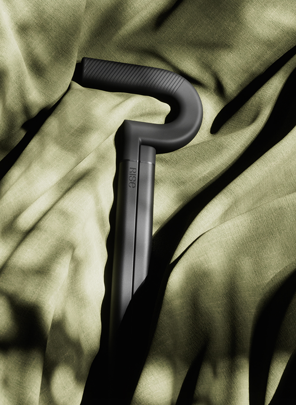 The Rise cane handle resting on olive fabric, portrait crop