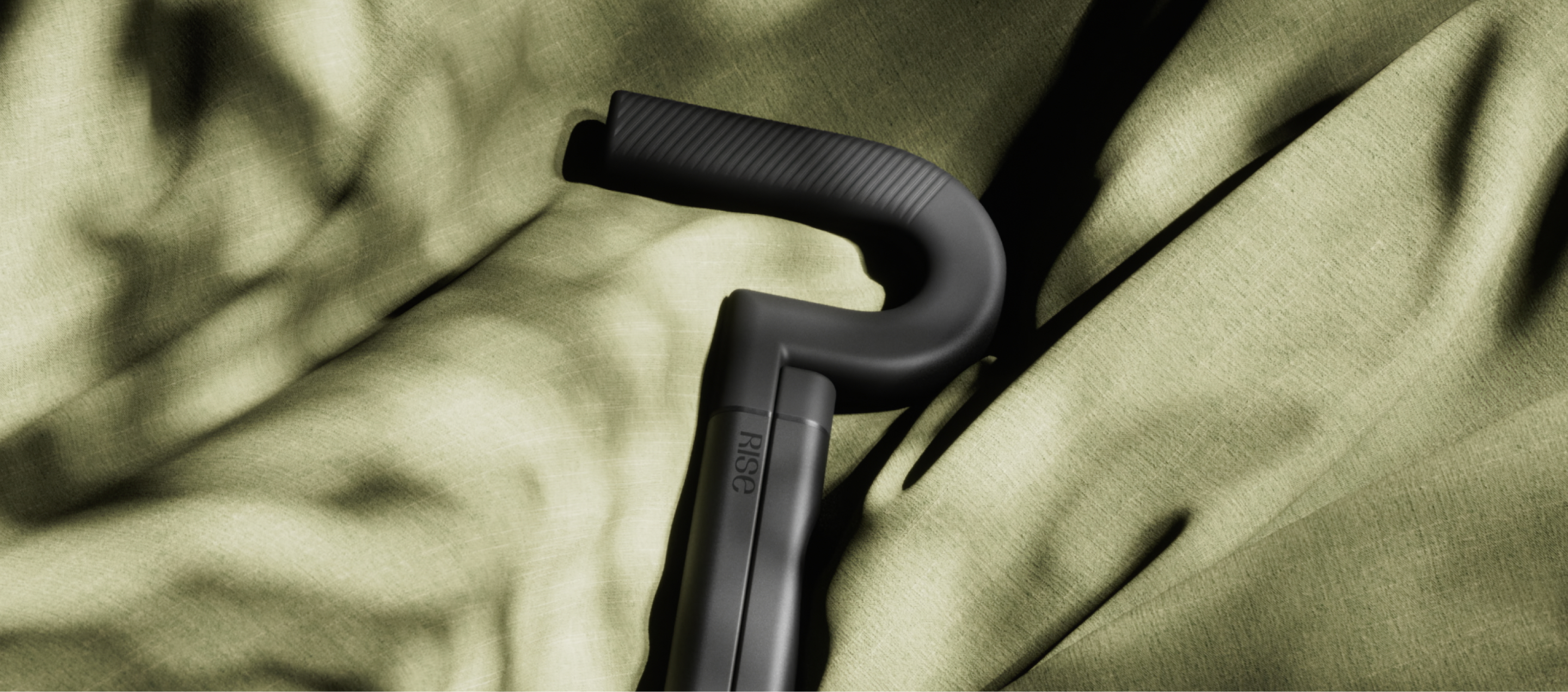The Rise cane handle resting on olive fabric