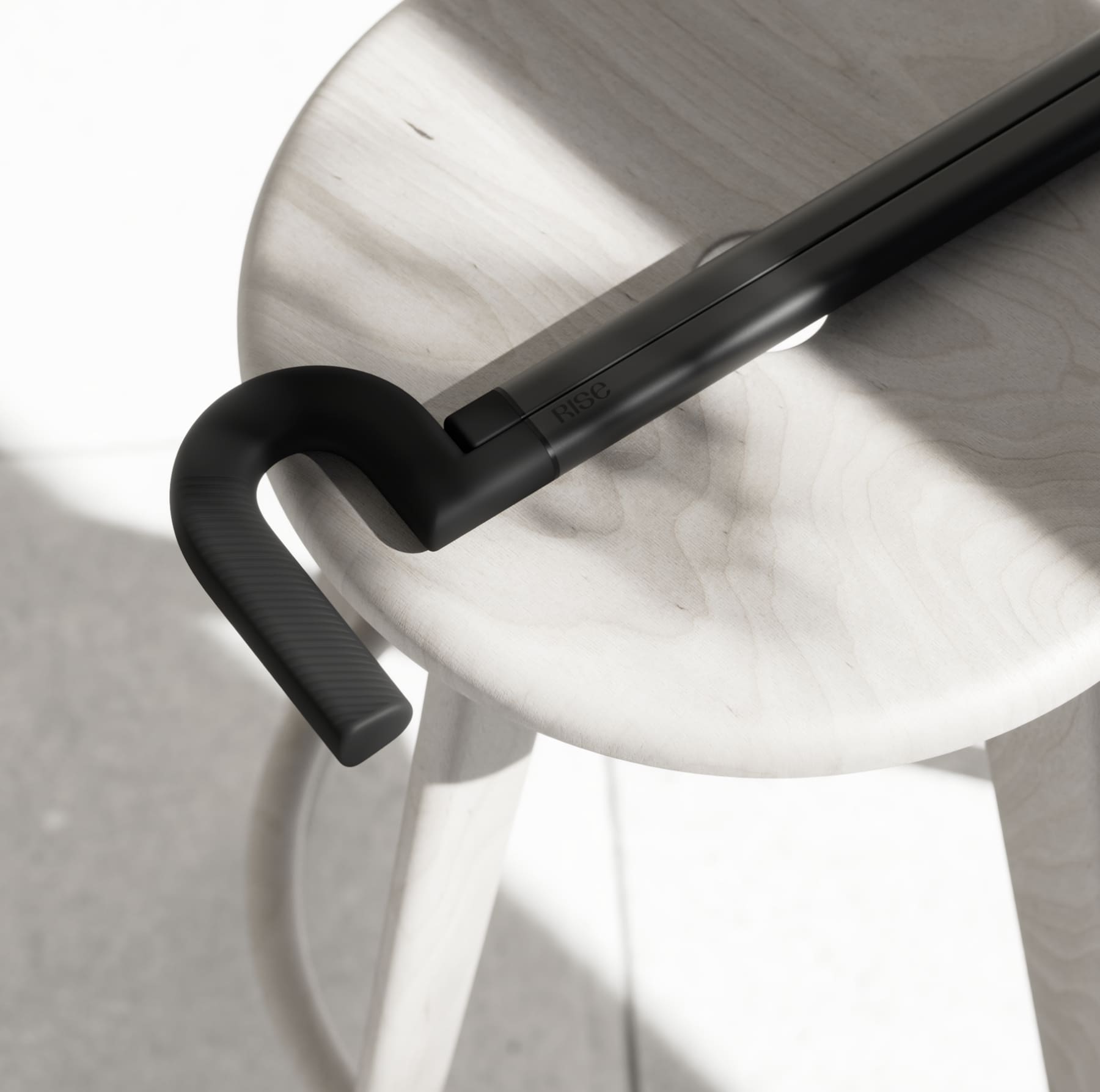 Close-up of the Rise cane on a wooden stool