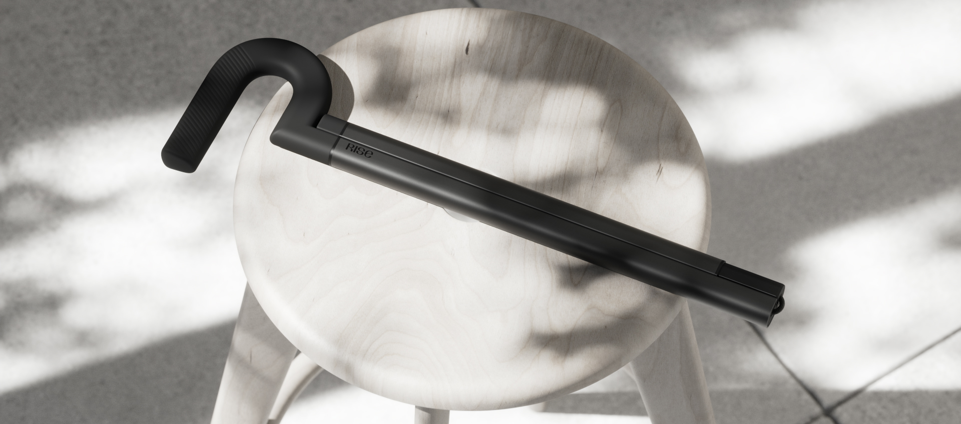 The Rise cane resting across a wooden stool