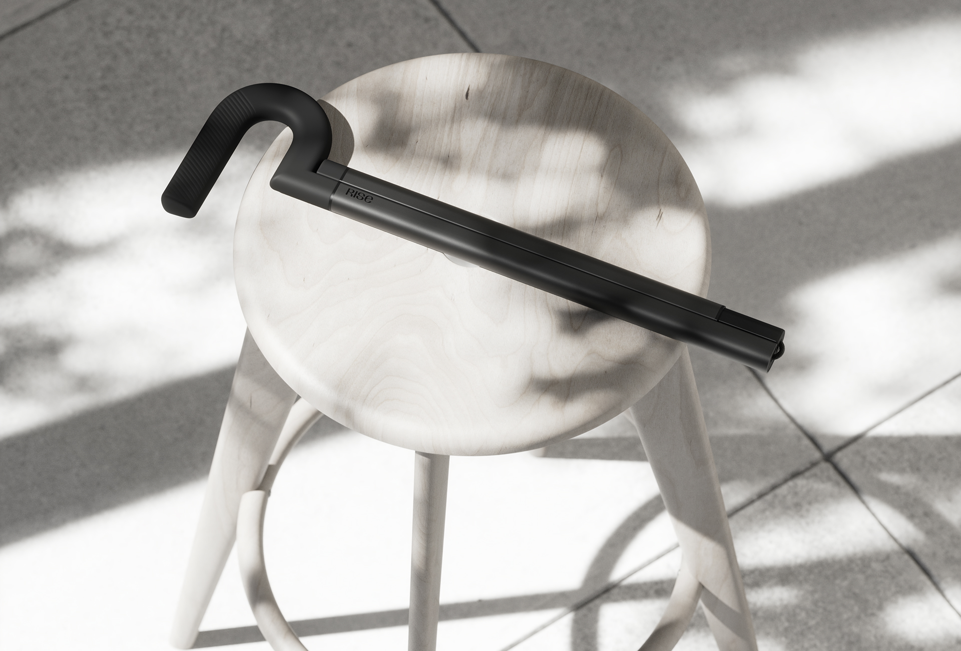 The Rise cane leaning on a stool beside travel luggage