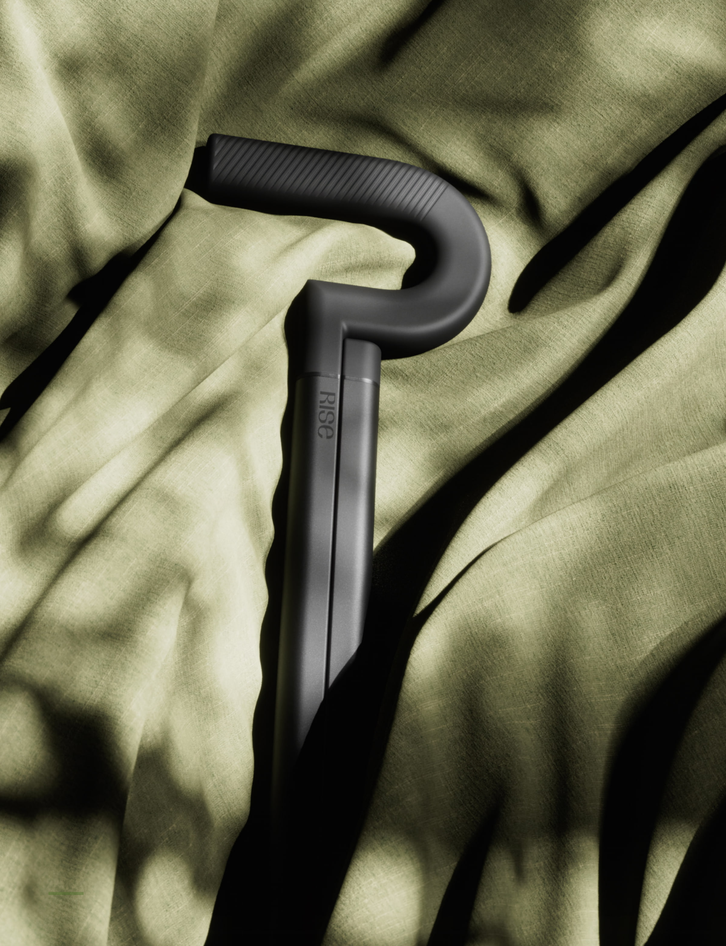 The Rise cane handle resting on olive linen